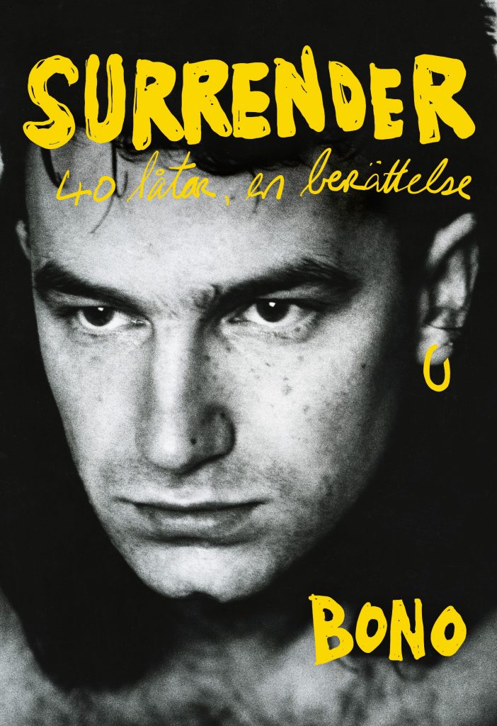 Bokomslag för "Surrender - 40 låtar en berättelse", Bonos memoarer som ges ut på svenska av Bokförlaget Polaris AB. På omslaget syns ett svartvitt fotografi av Bono från 1985, med handskriven titel i gul text.